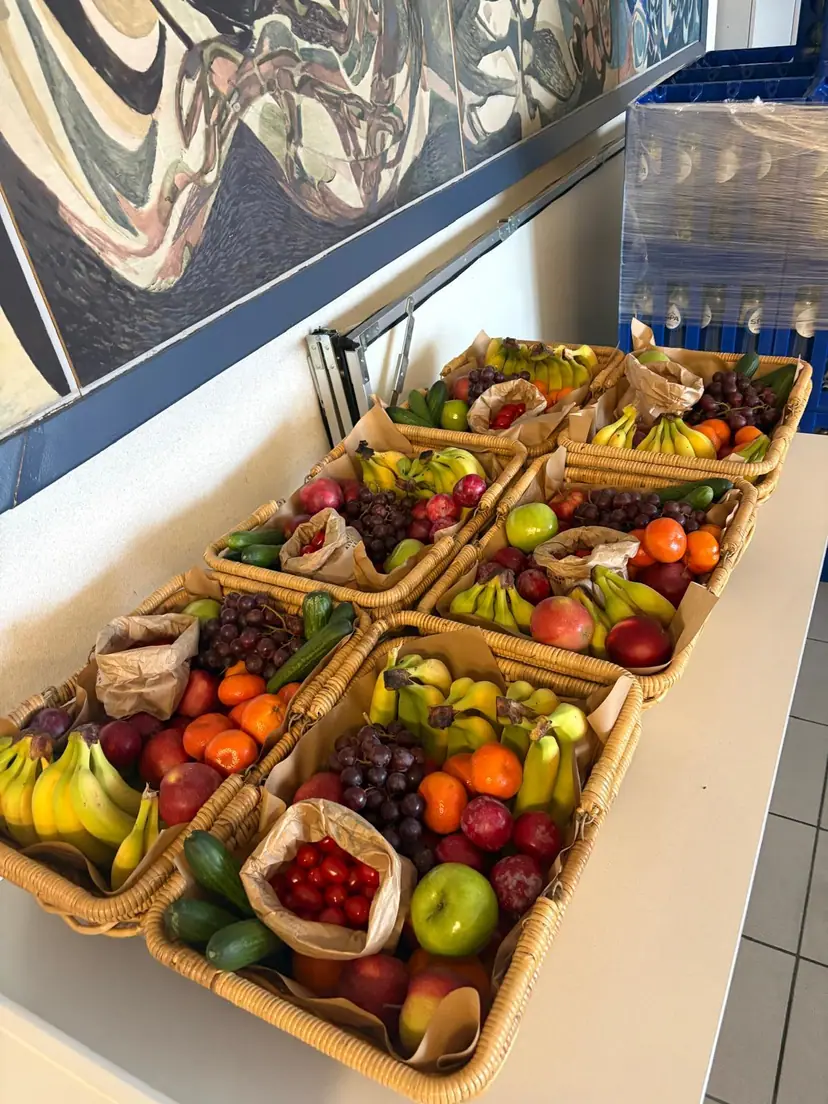 Een tafel vol fruitmanden in de gang van een kantoor